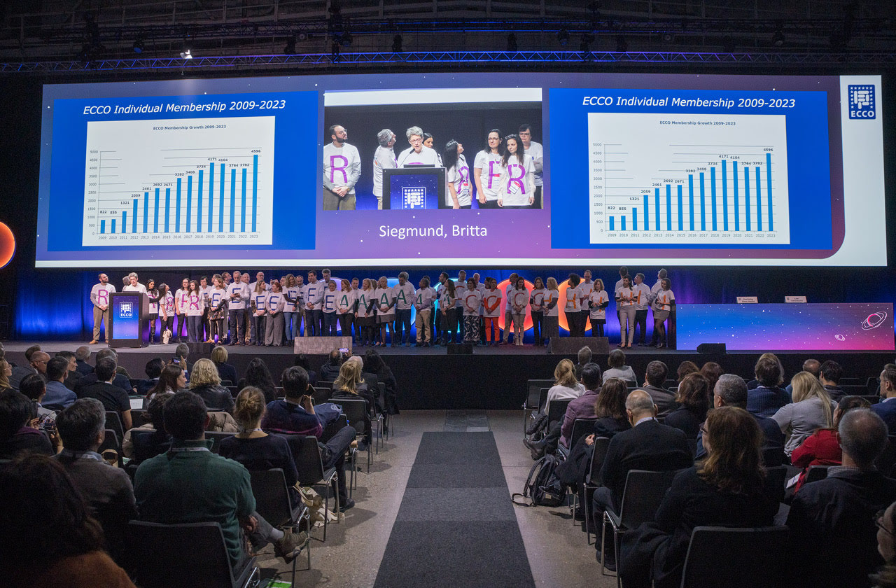 behind many people on the ECCO’24 stage are graphs and photos displayed on a big screen